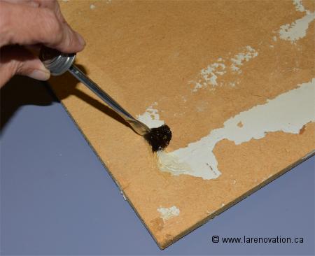 Photo de l'application de la colle contact sur la tuile de plafond