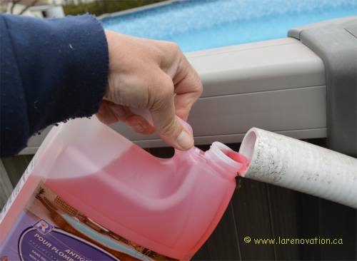 Photo du remplissage du tuyau de drain avec de l'antigel