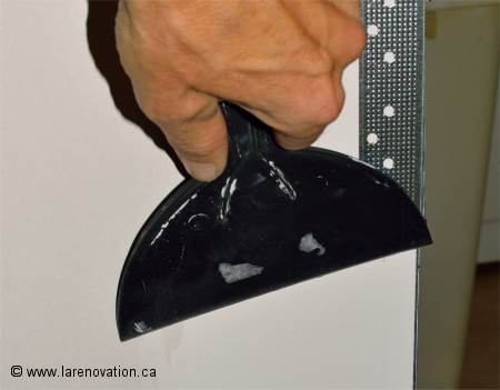 Tirer les joints des coins de fer avec une spatule