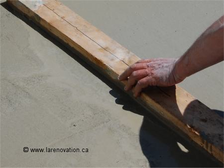 Utilisation d'un 2x4 pour placer le mortier