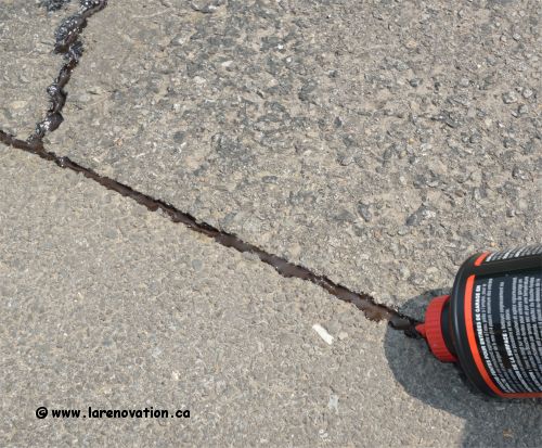 Photo du colmatage d'une fissures dans l'asphalte