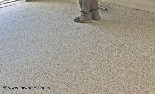Application des flocons de vinyle sur la couche de polyur�a du plancher de b�ton